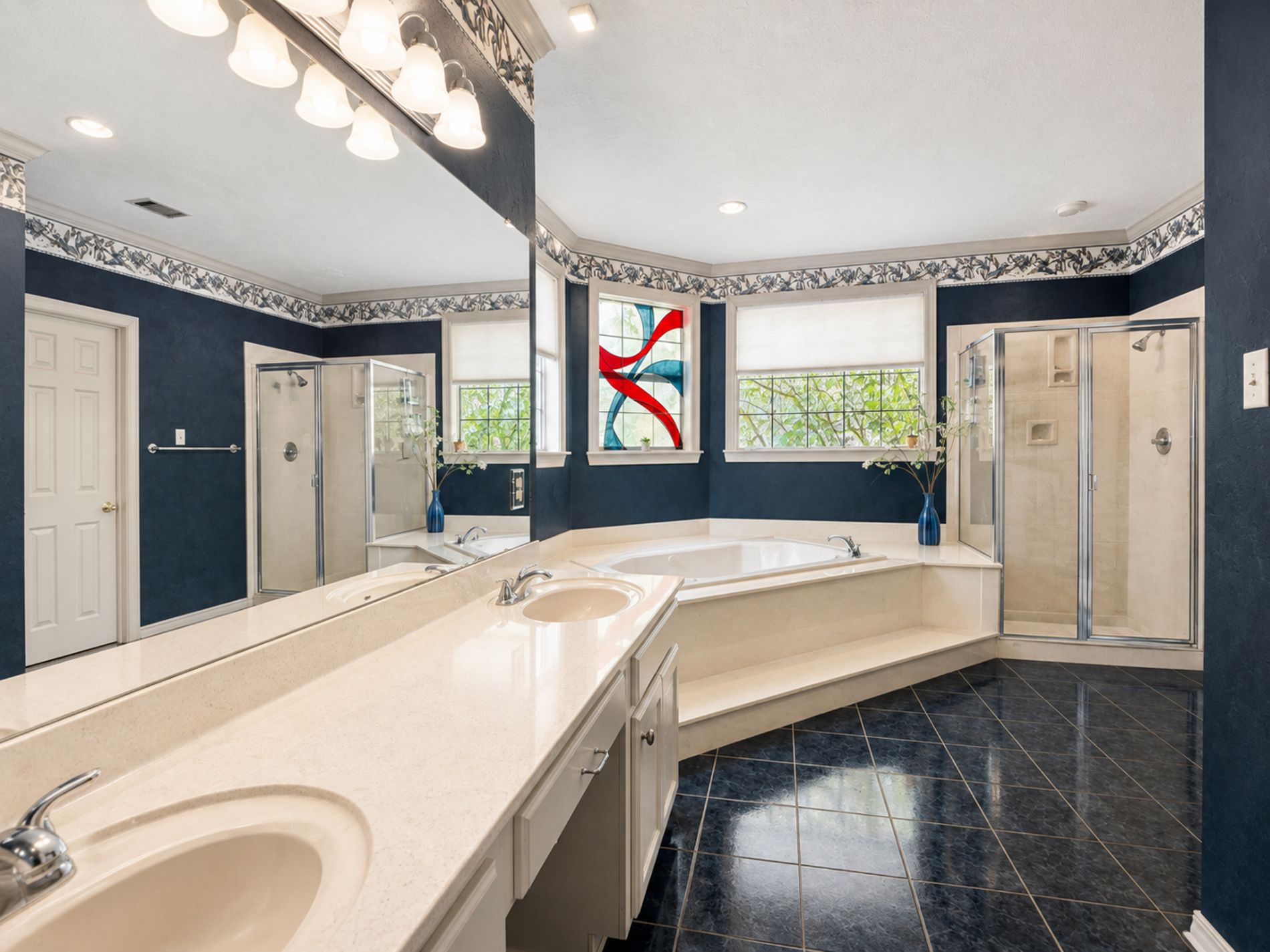Primary bathroom with double sinks, soaking tub, shower, and large walk-in closet Primary bathroom with double sinks, soaking tub, shower, and large walk-in closet